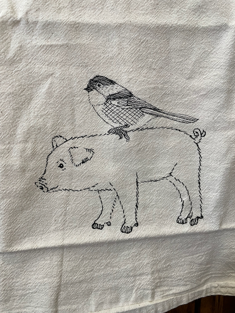 Tea towel with image of a bird on a pig's back
